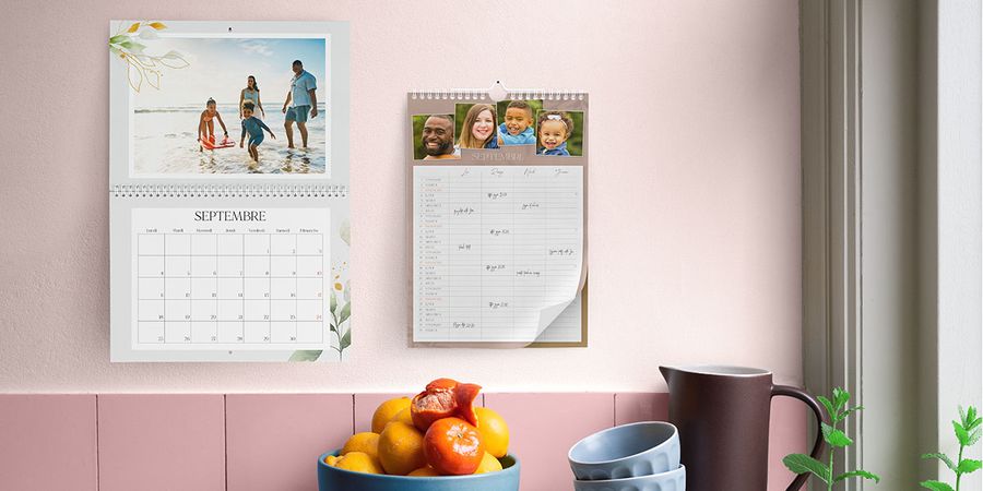 Un calendrier scolaire accroché à un mur rose